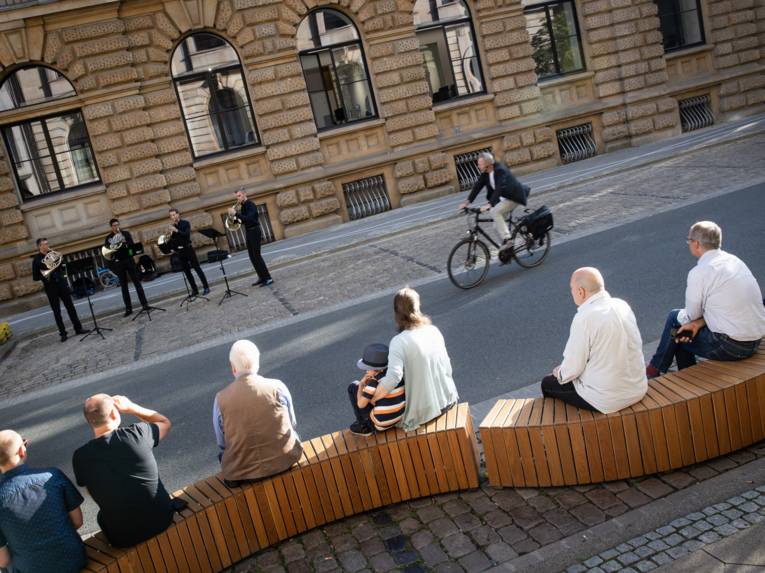 Menschen im öffentlichen Raum, die Musik lauschen.